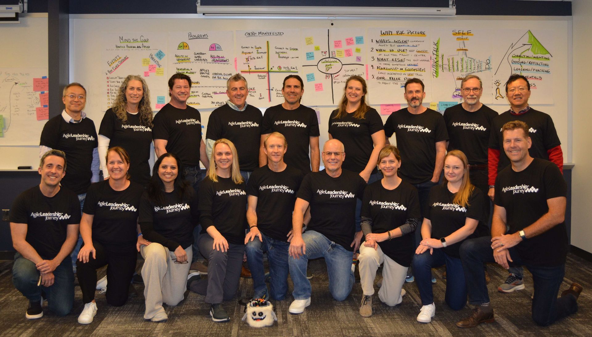 A group of people wearing black shirts are posing for a picture.