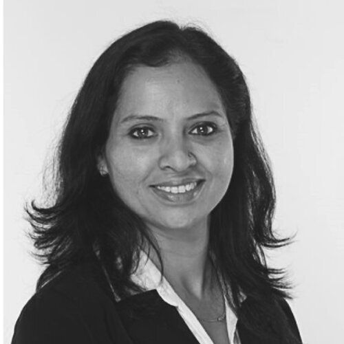 A woman is smiling in a black and white photo.