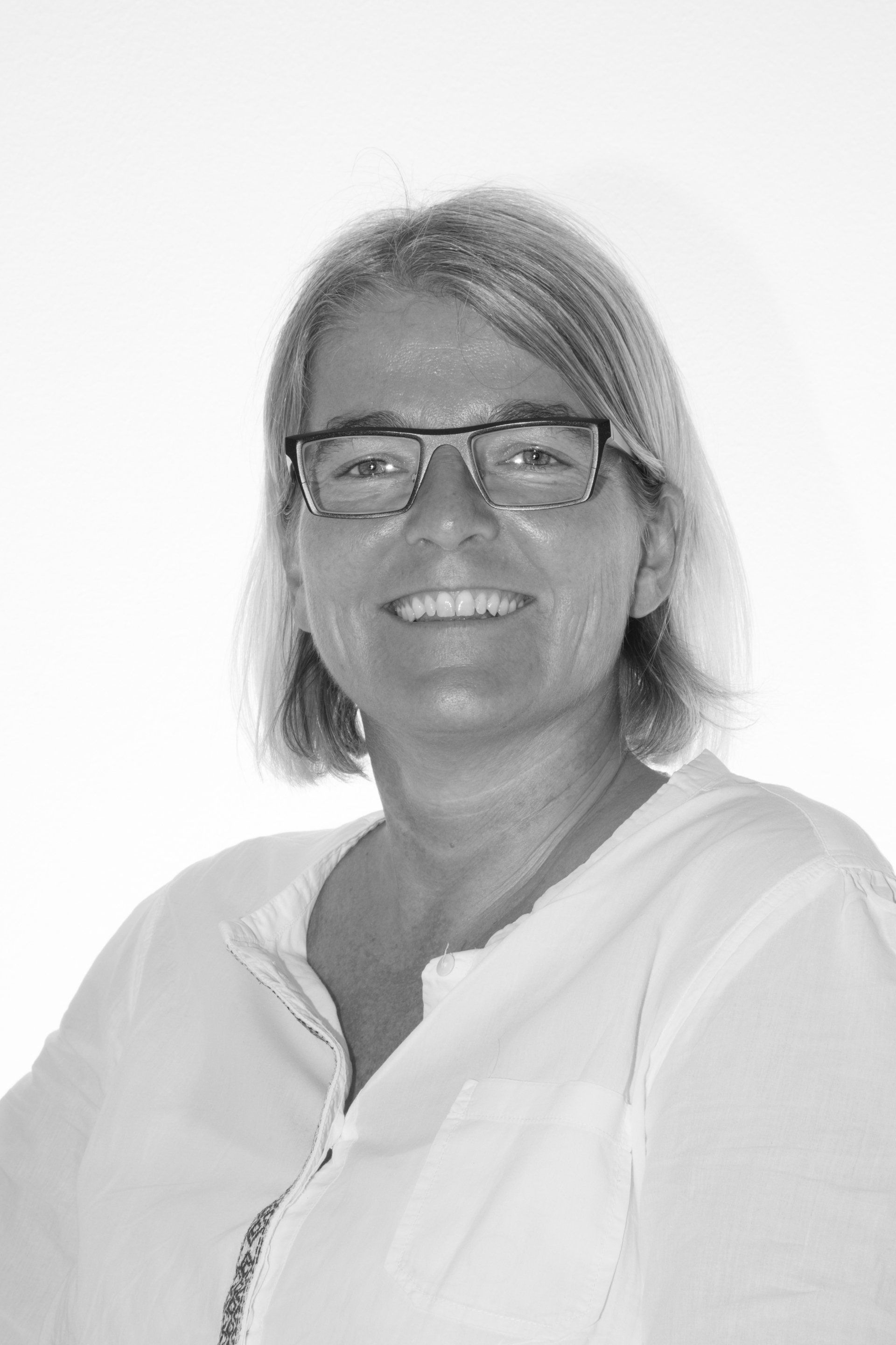 A black and white photo of Mette Bjerrekaer, a white woman with short blonde hair and glasses