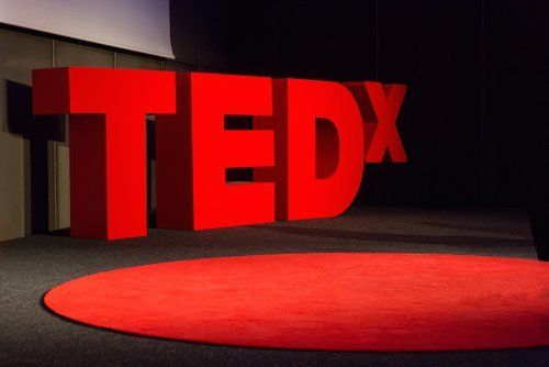 A picture of an empty TEDx stage, with the TEDx behind the signature red circle carpet