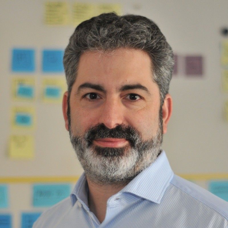 A man with a beard is smiling for the camera