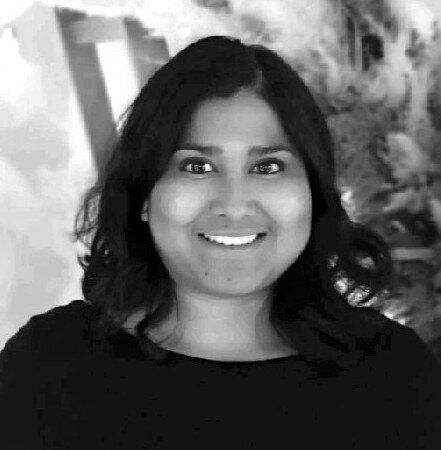 A black and white photo of a woman smiling for the camera.