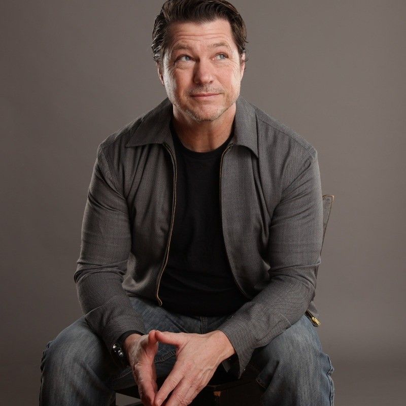 Christina Carlson is standing in front of a white wall and smiling.