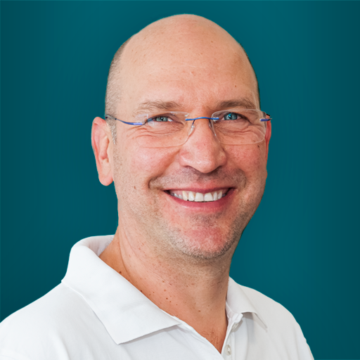 A smiling bald man wearing glasses and a white shirt