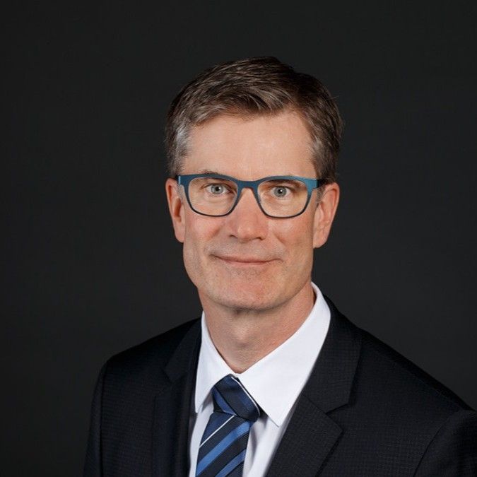 A man in a suit and tie is wearing glasses.