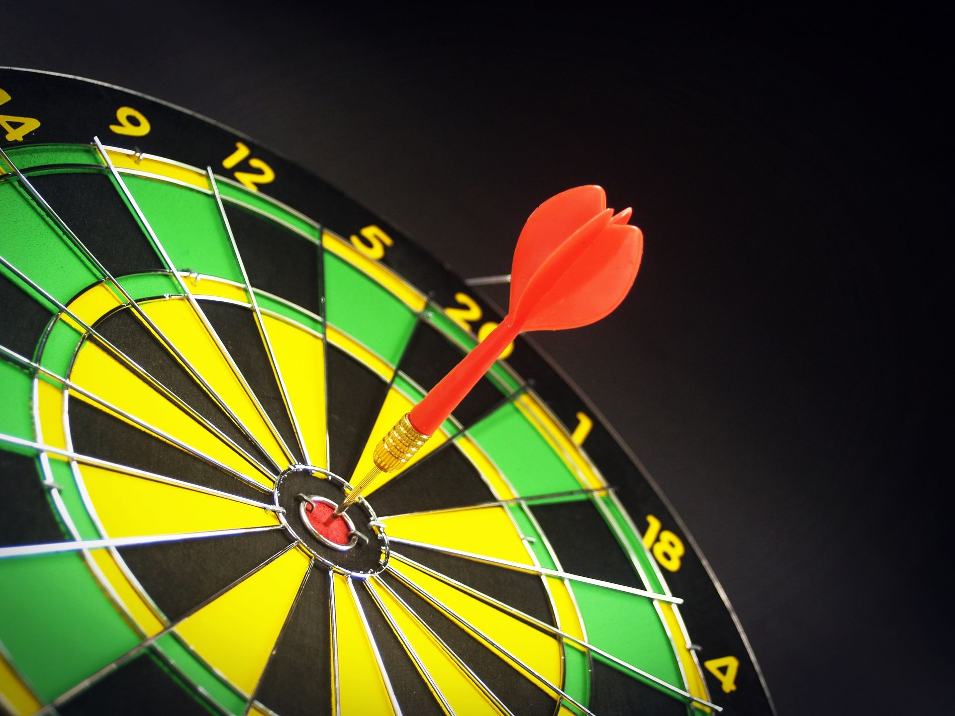 Dartboard with a red dart in the center