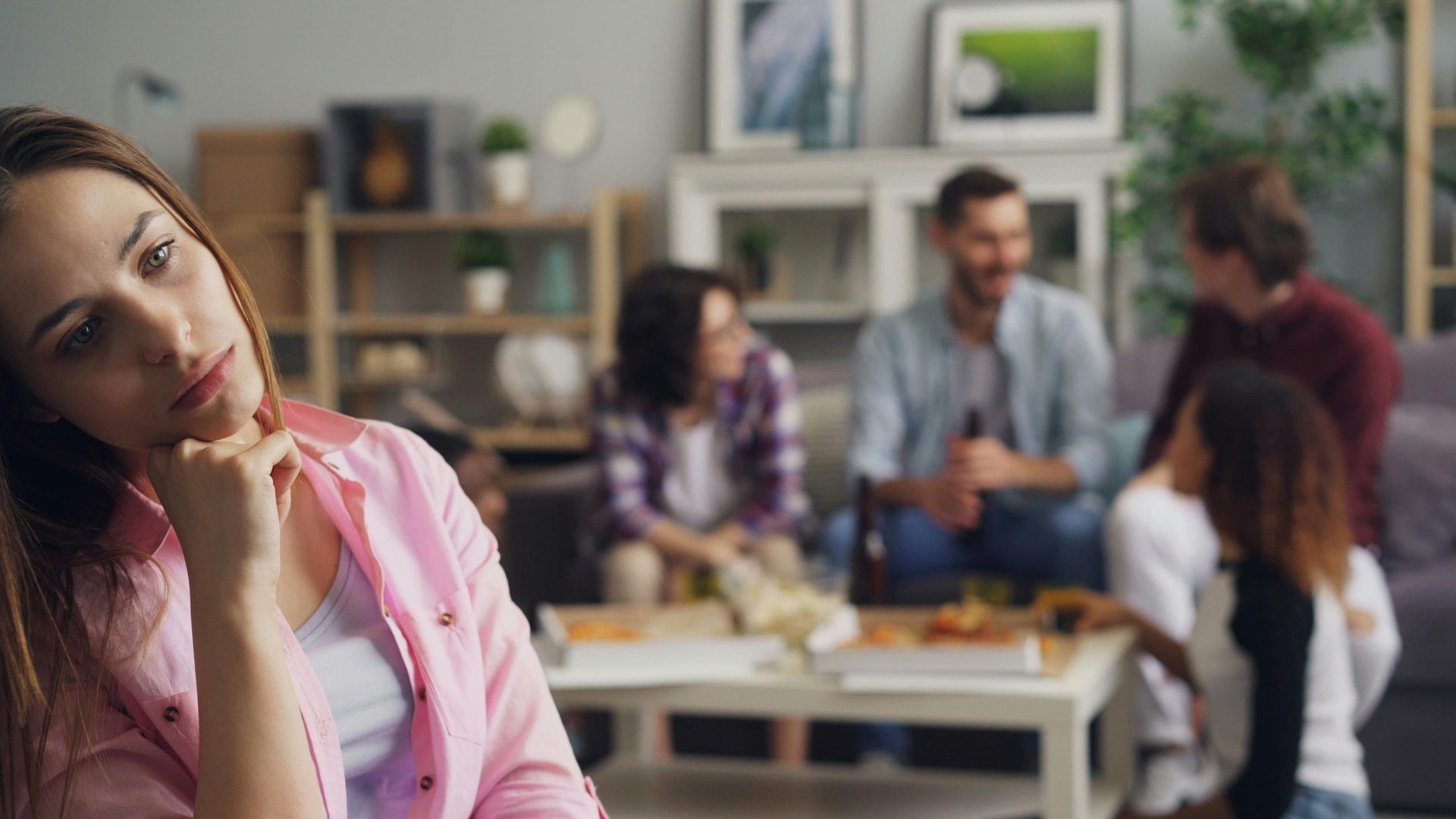 A woman is sitting in front of a group of people in a living room.