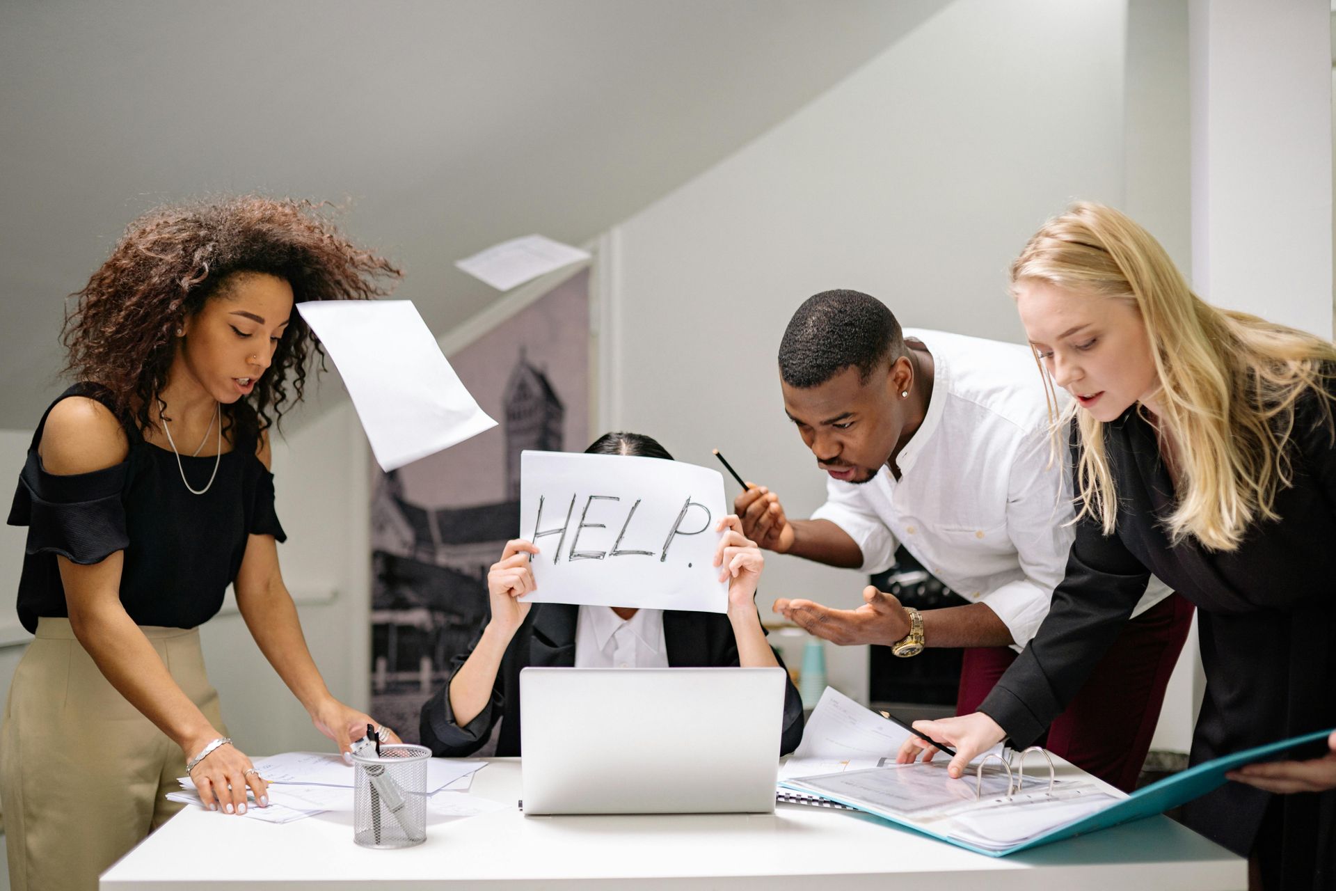 A group of people are standing around a table holding a sign that says 