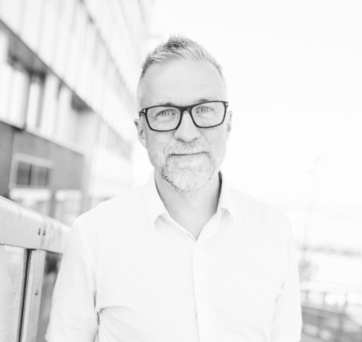 A black and white photo of a man wearing glasses and a beard.