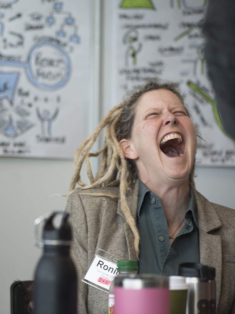 a white woman with blonde dreadlocks laughs hysterically