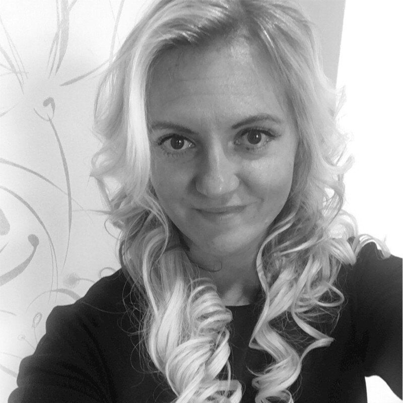 A woman with long blonde hair is taking a selfie in a black and white photo.