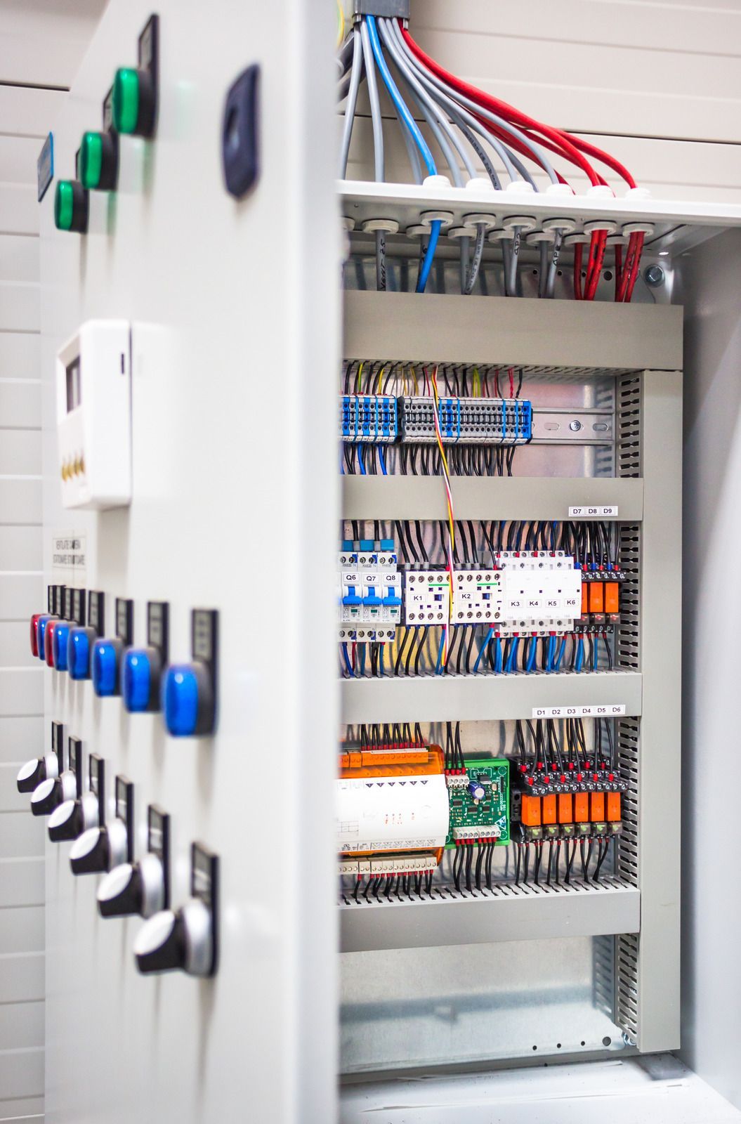 A electrical control panel with a lot of wires coming out of it.