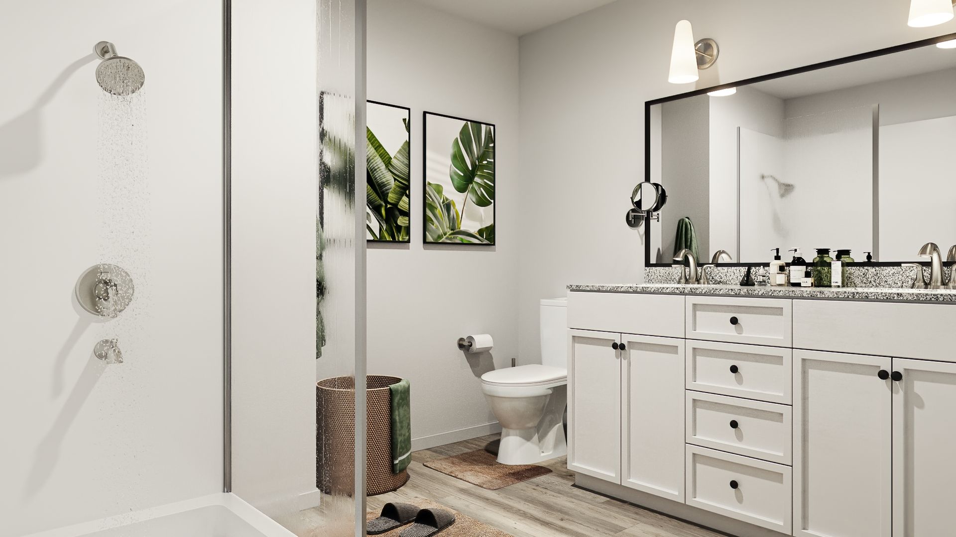 Bathroom with white cabinets, shower, toilet, and decorative art.