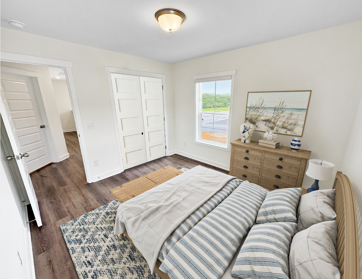 Bedroom with bed, dresser, rug, window, and closet. Light wood floors and white walls.