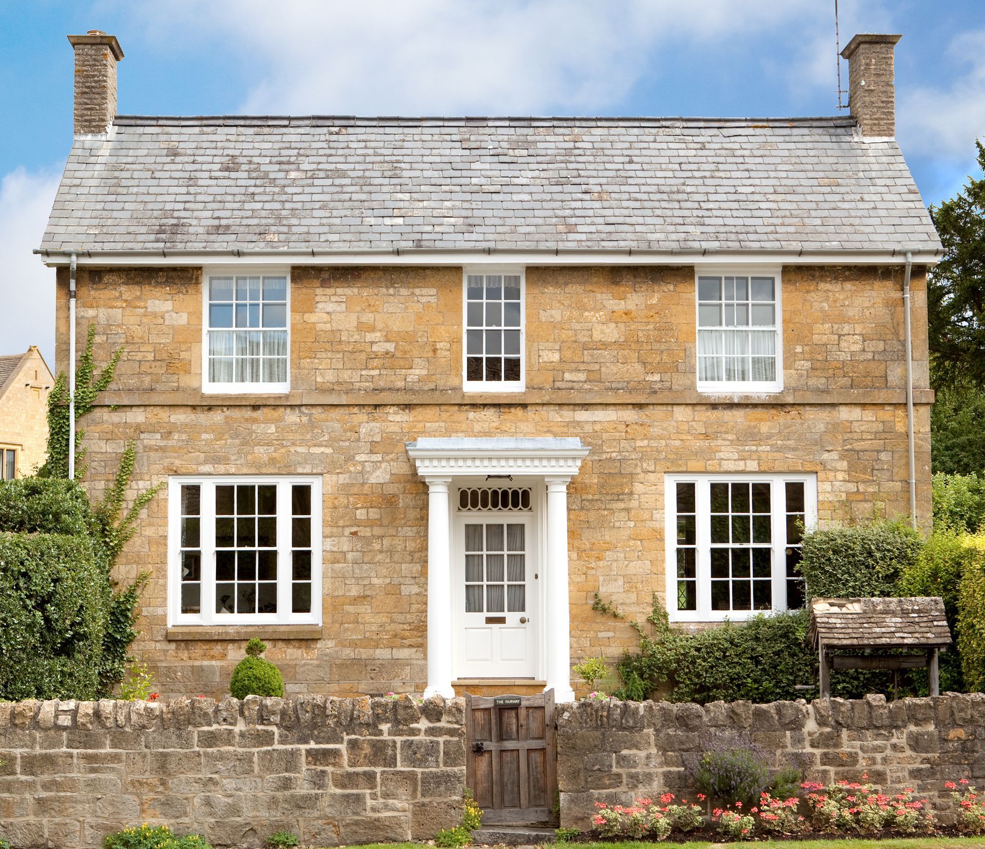 A large brick house with white windows and a slate roof