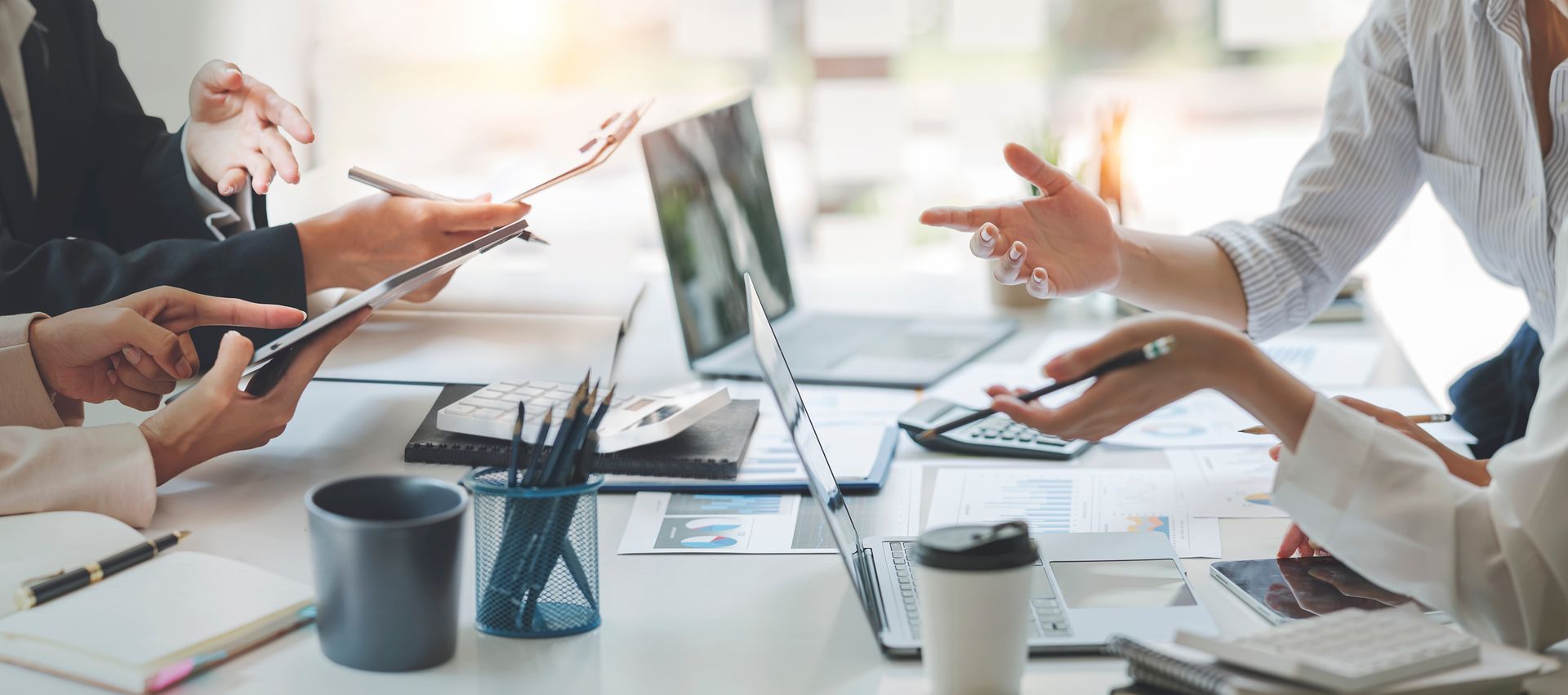 A close-up of a hand selecting one of many thin, parallel wooden sticks or tools arranged on a table.