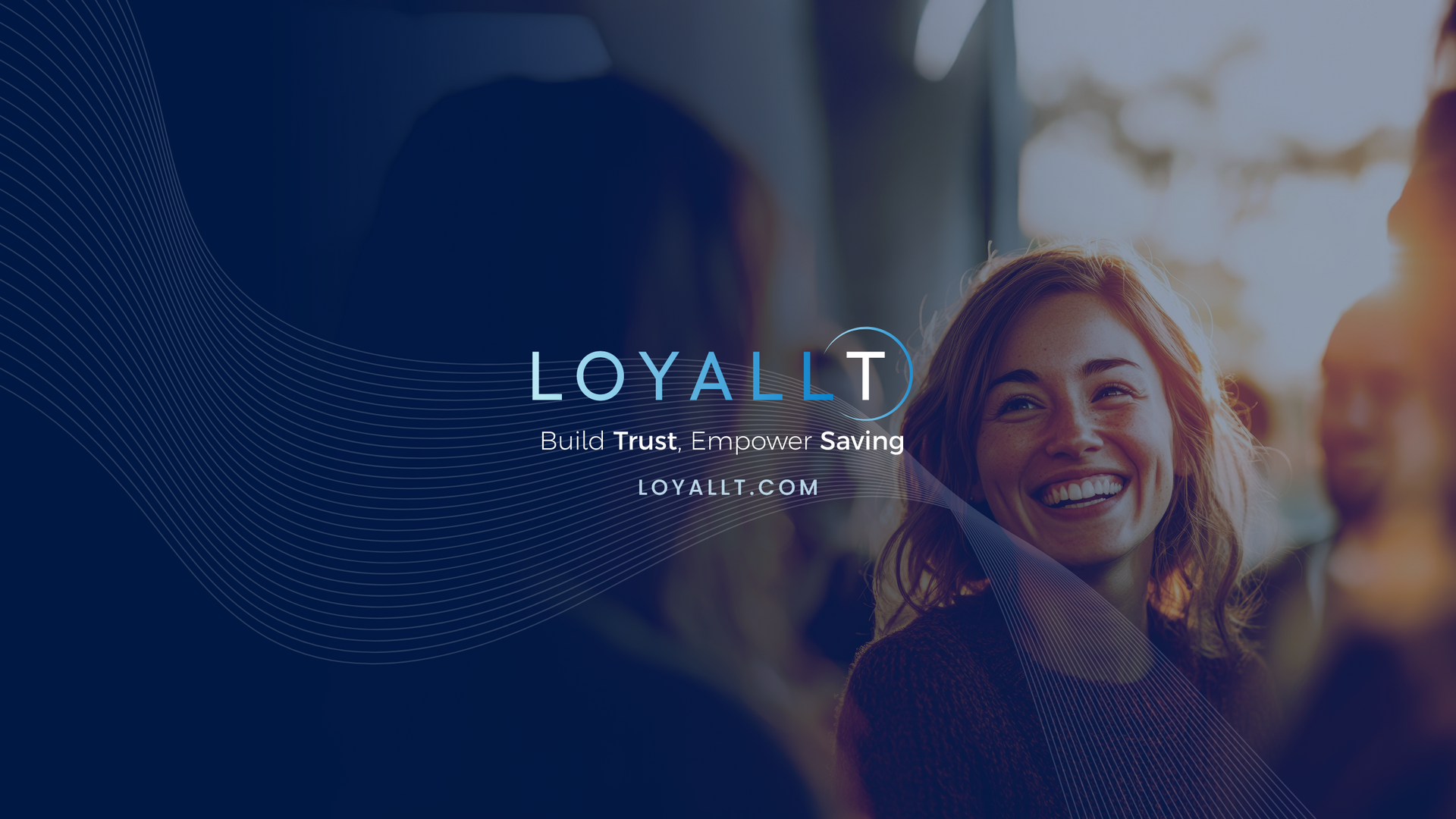 A smiling person in a dimly lit setting with the LOYALLT logo and website overlaid in white text.