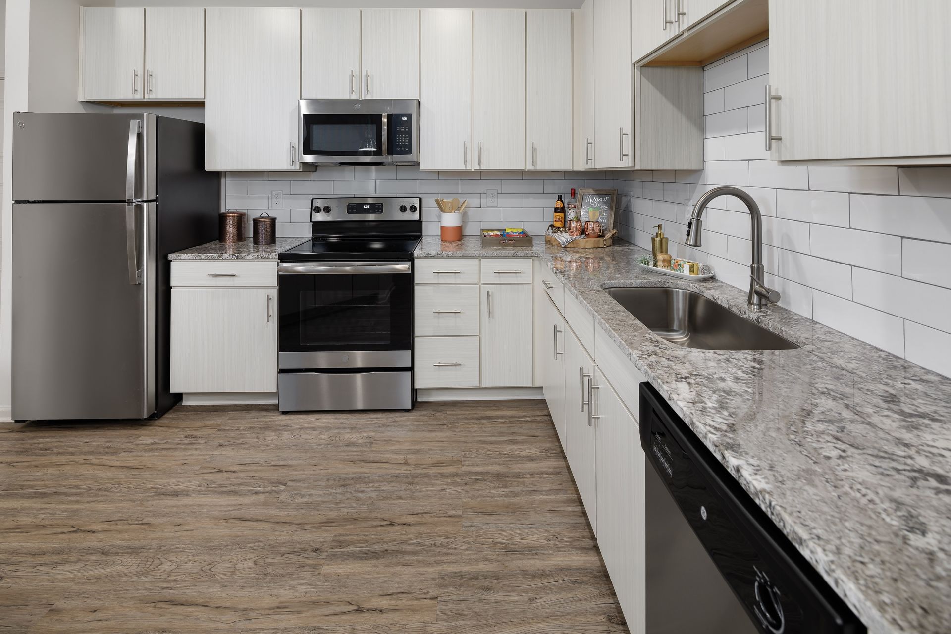 Modern kitchen with stainless steel appliances and white cabinets.