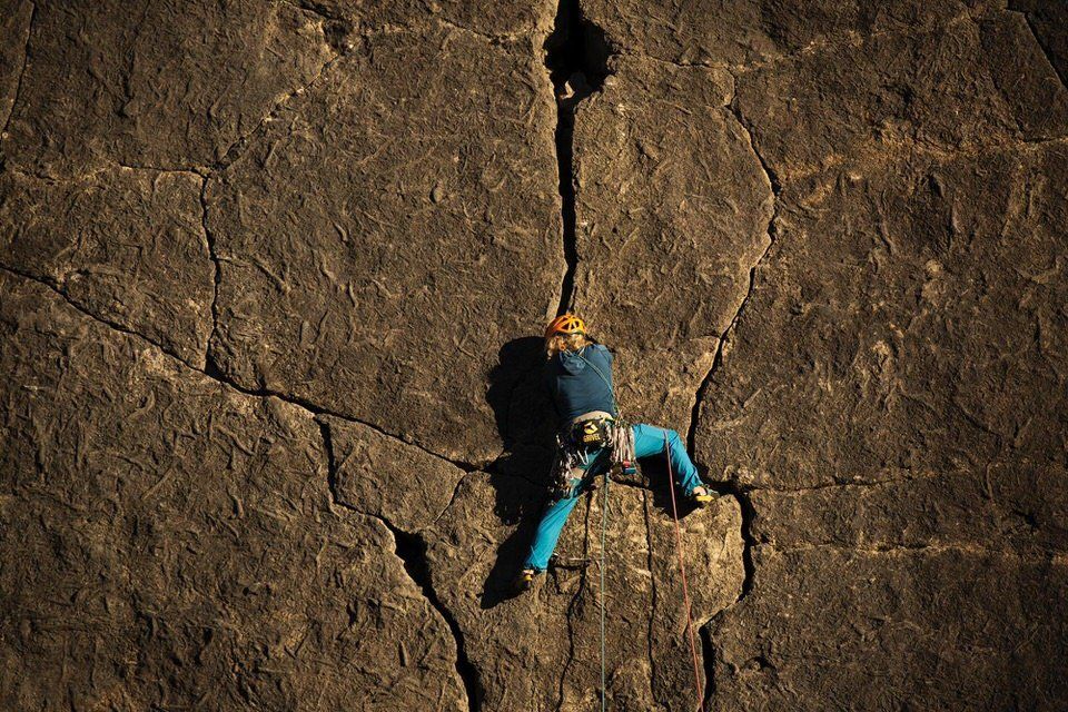 Climber with blue trousers climbing a crack
