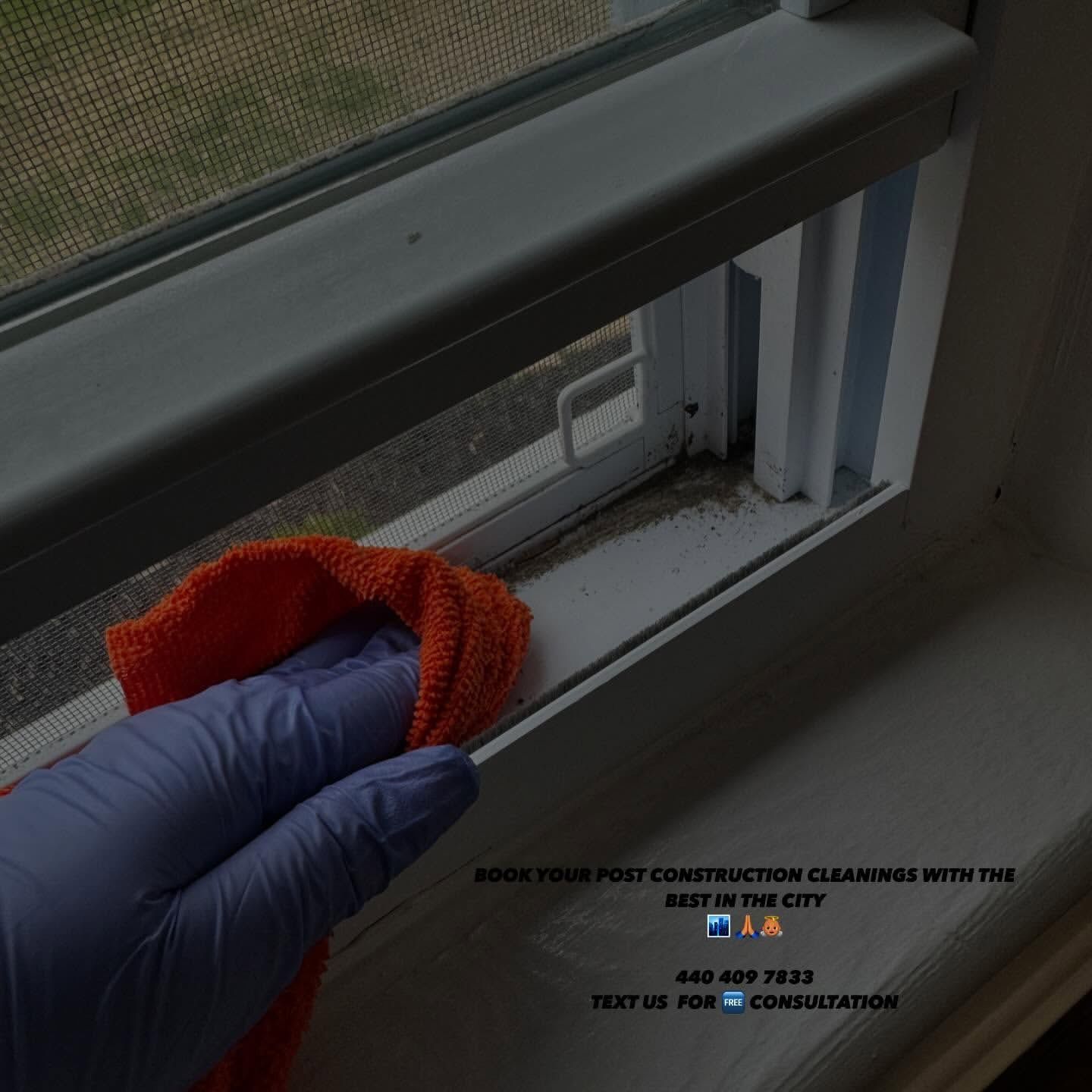 Person in blue glove wiping a dirty window sill with an orange cloth.