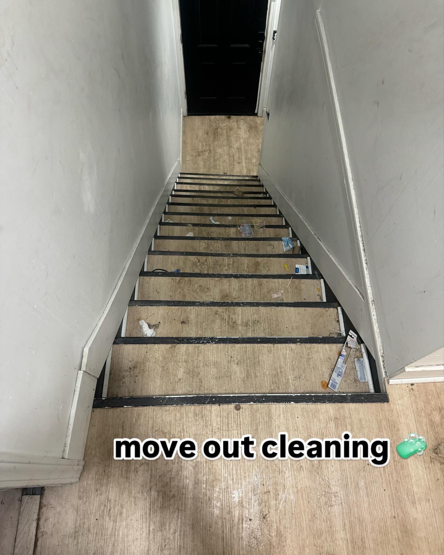 View down a narrow, dirty staircase; white walls, worn beige steps, 