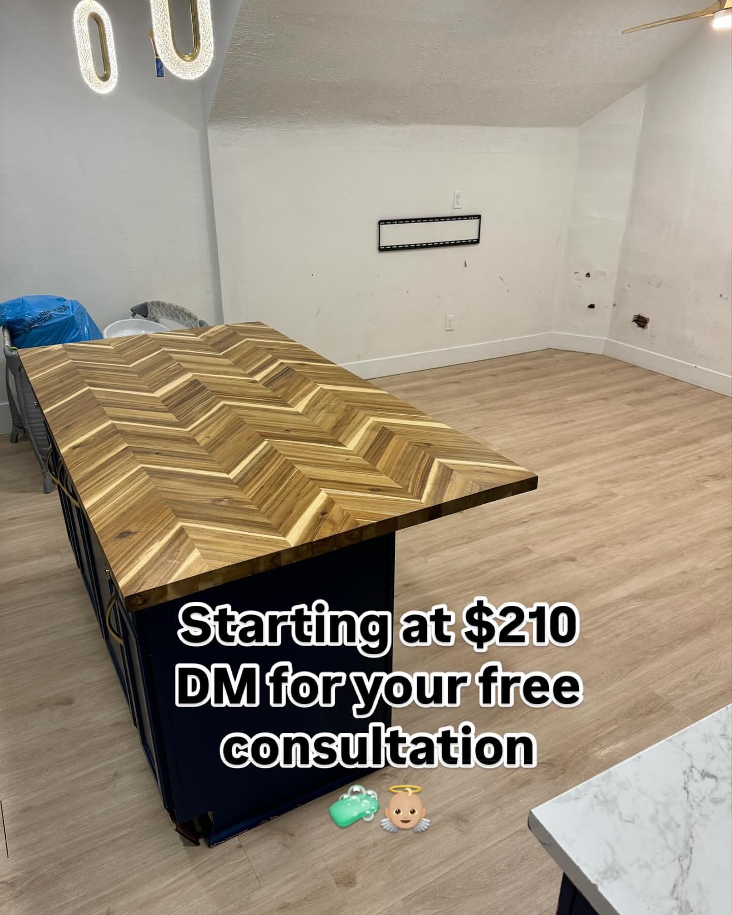 Kitchen island with herringbone wood top, dark blue base, light wood floor, advertising starts at $210.