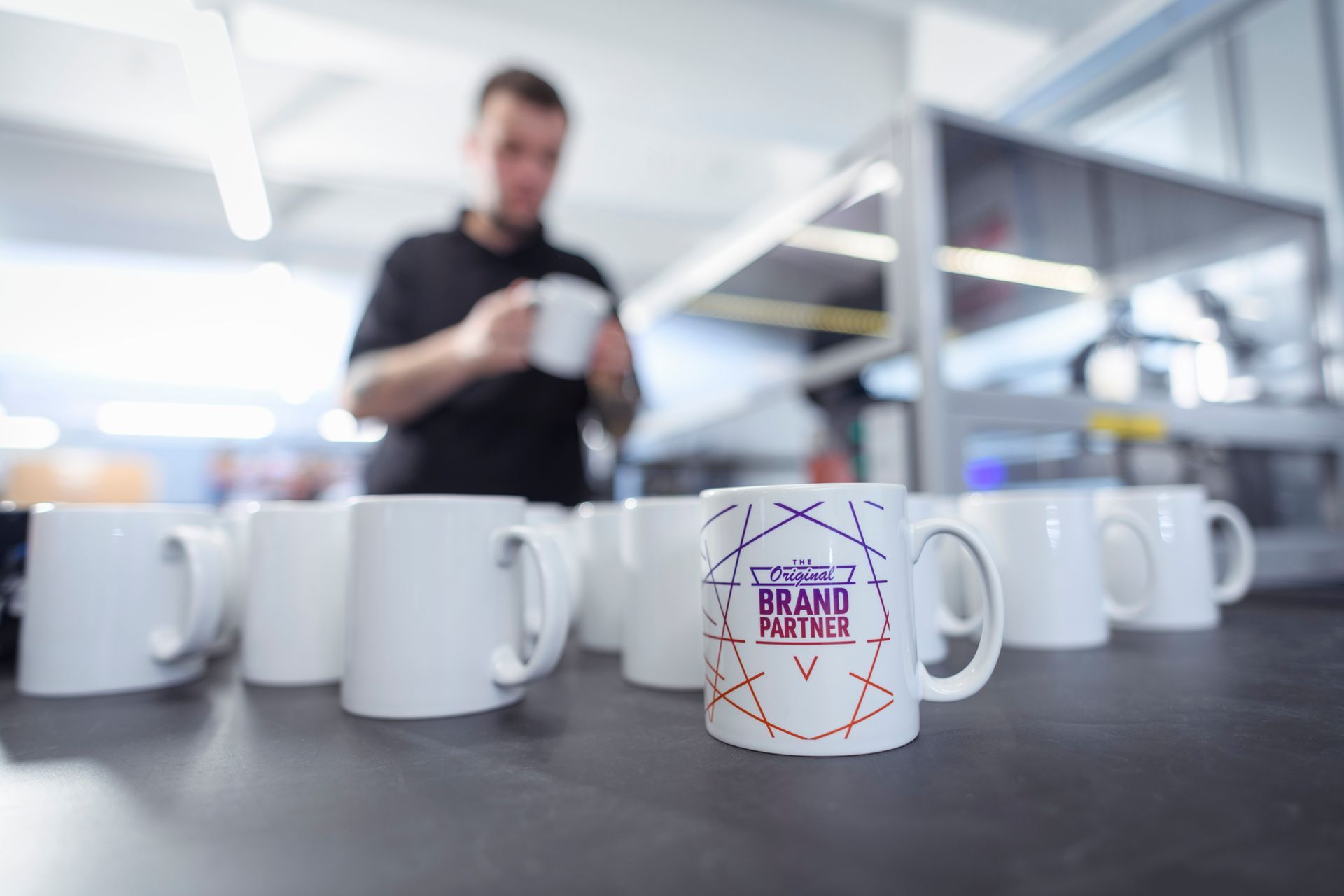 Worker inspecting printed mugs in a fabric printing factory. Worker inspecting printed mugs in a fabric printing factory.