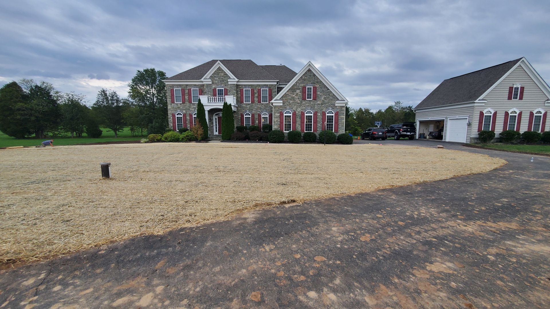 A large house with a gravel driveway in front of it.