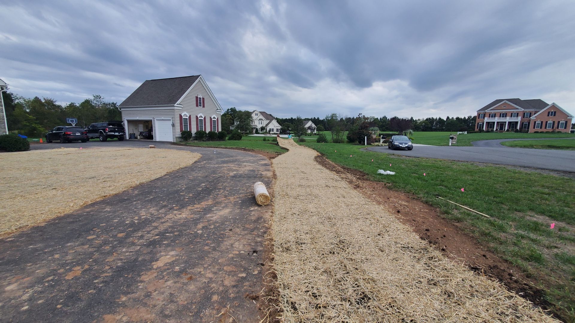 A gravel driveway leading to a house in a residential area.