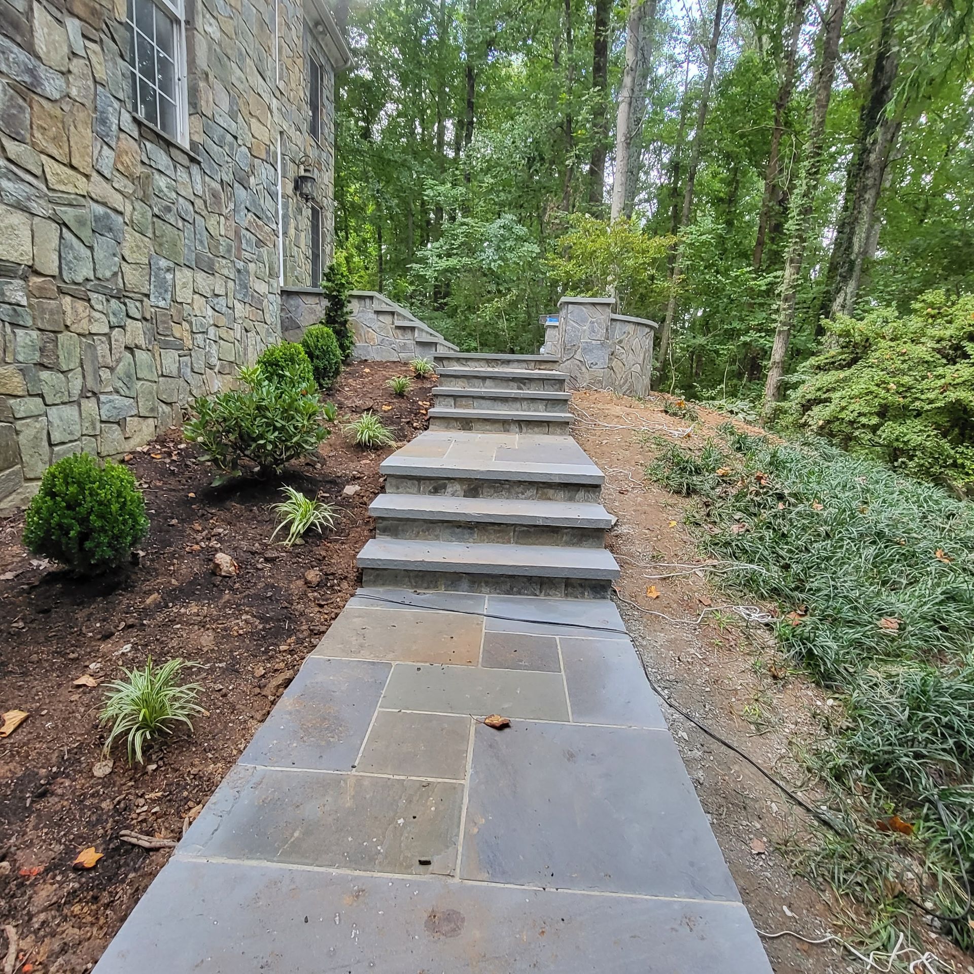 A stone walkway with stairs leading up to a house