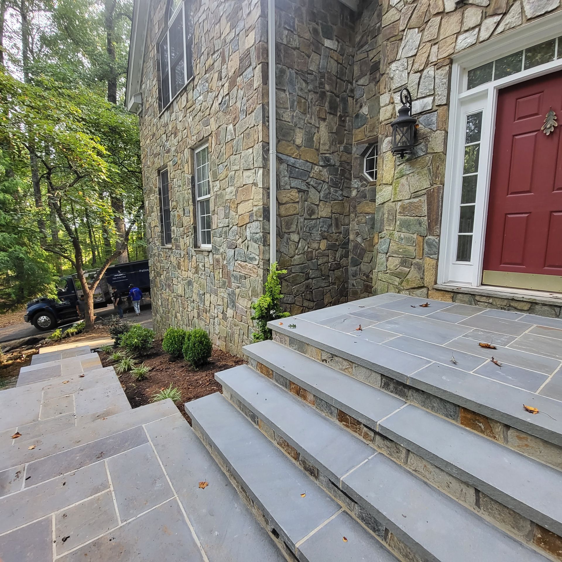 A stone house with a red door and stairs