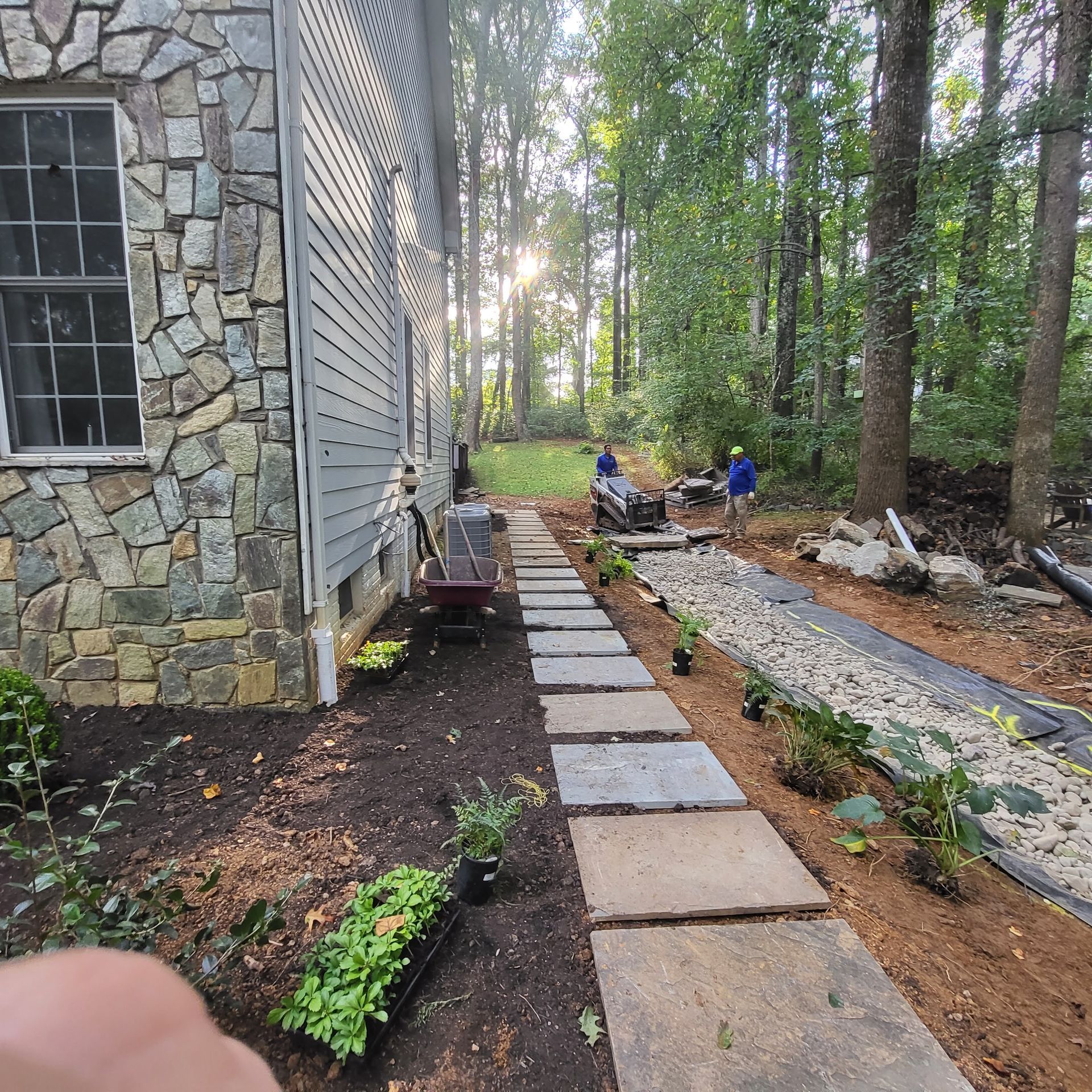 A stone walkway leading to a house in the woods