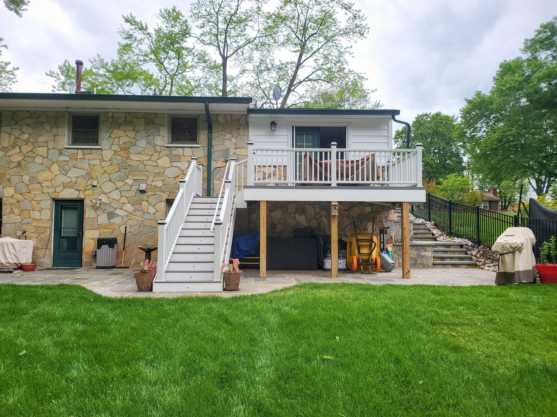 The back of a house with a large deck and stairs.