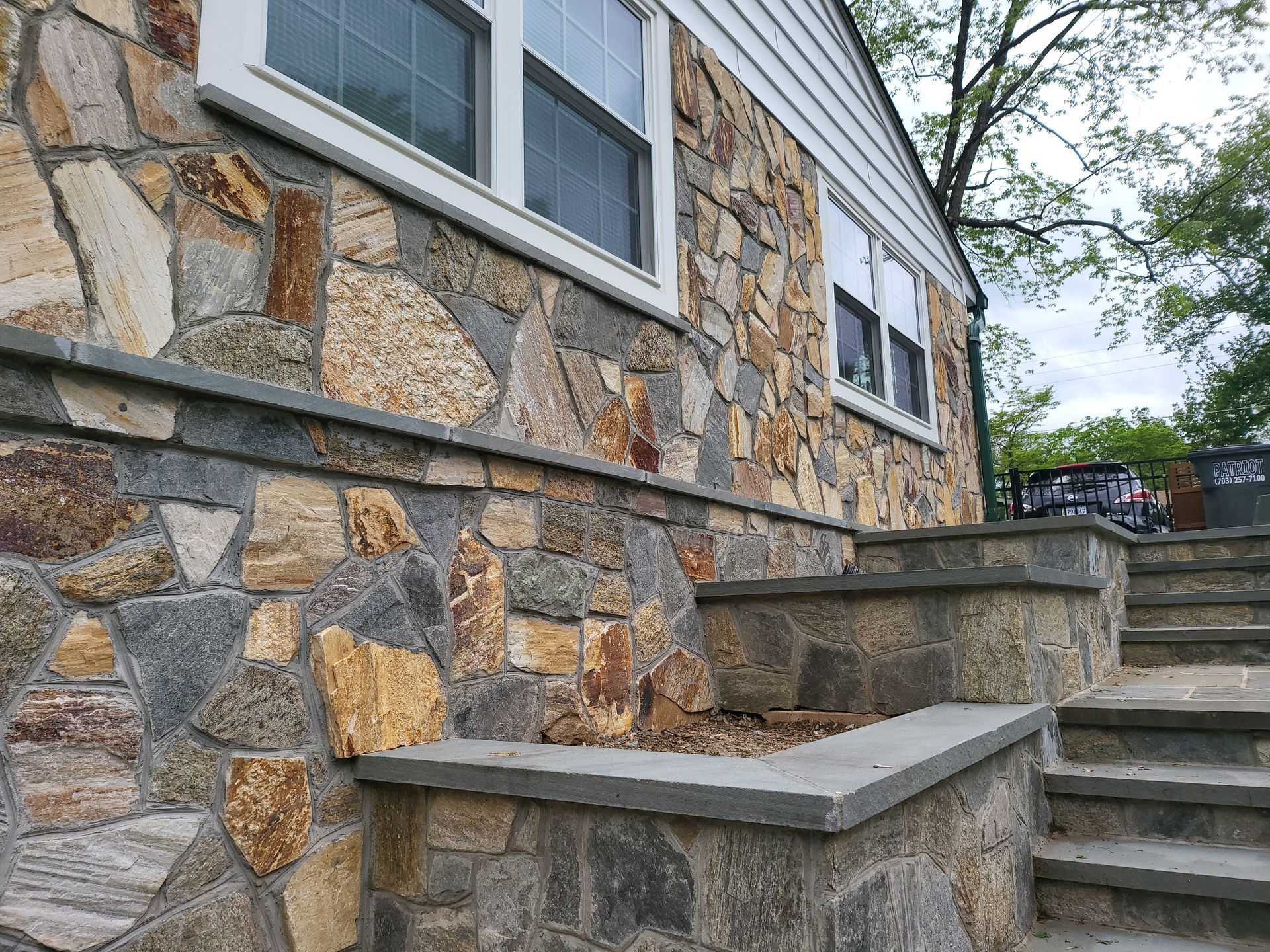 A house with a stone wall and stairs leading up to it