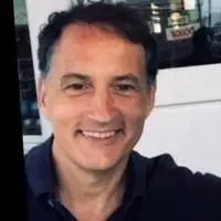 A man in a black shirt is smiling for the camera.