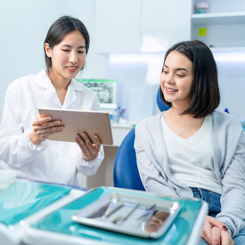 Asian Young Female Dentist Holding Digital Tablet — Bunbury WA — FADC Dental Group