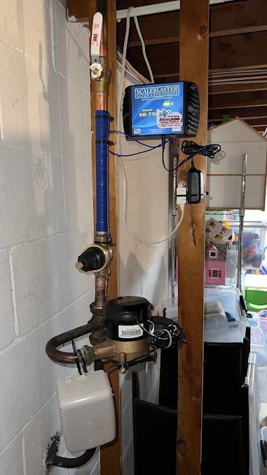A water pump is attached to a pipe in a basement.