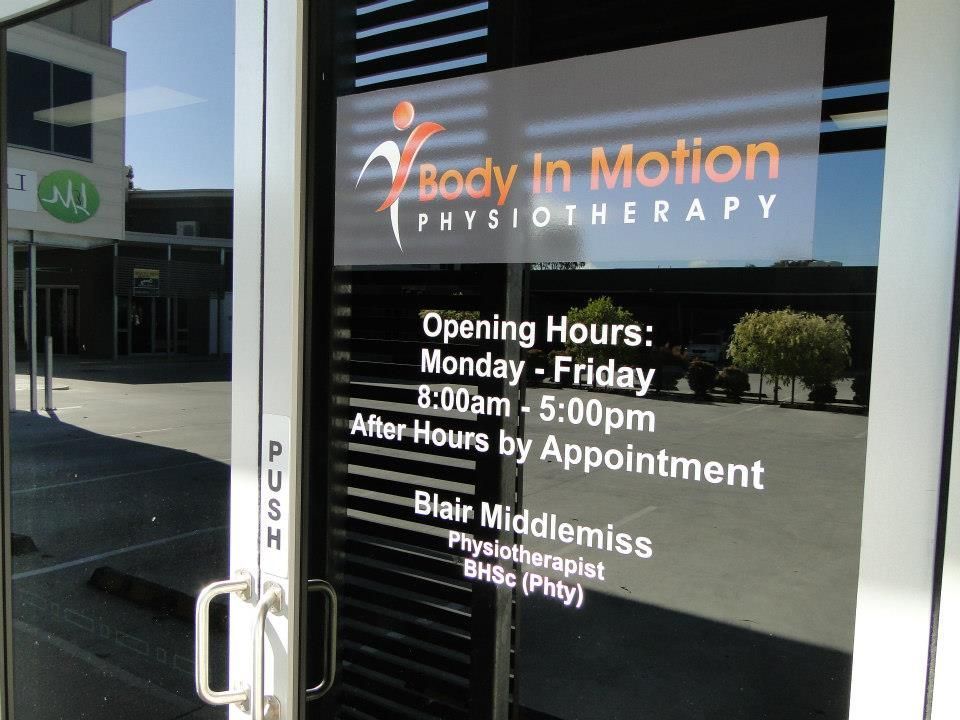 A body in motion physiotherapy sign on a glass door