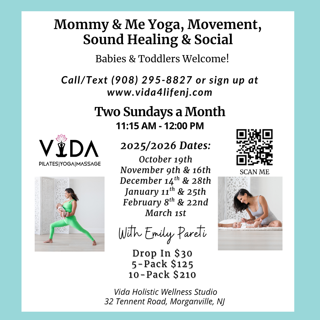 A woman is sitting on a bed holding a baby.