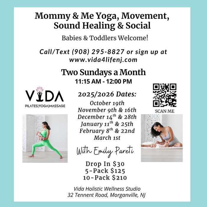 A woman is sitting on a bed holding a baby.