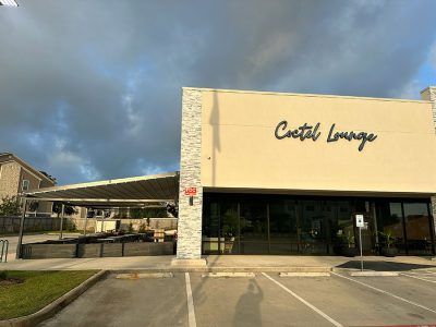 A large building with a lot of windows and a parking lot in front of it.