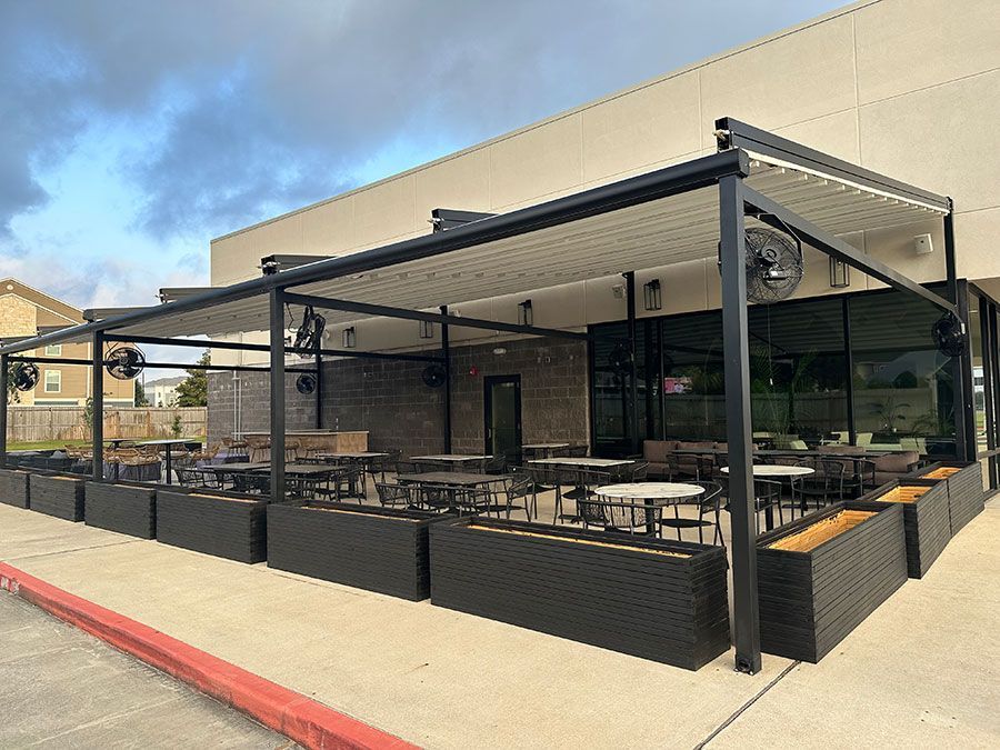 A restaurant with tables and chairs under a canopy.