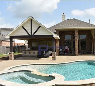 A house with a pool and a hot tub in front of it.
