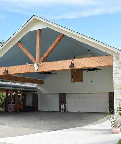 A large garage with a wooden roof and ceiling fans.