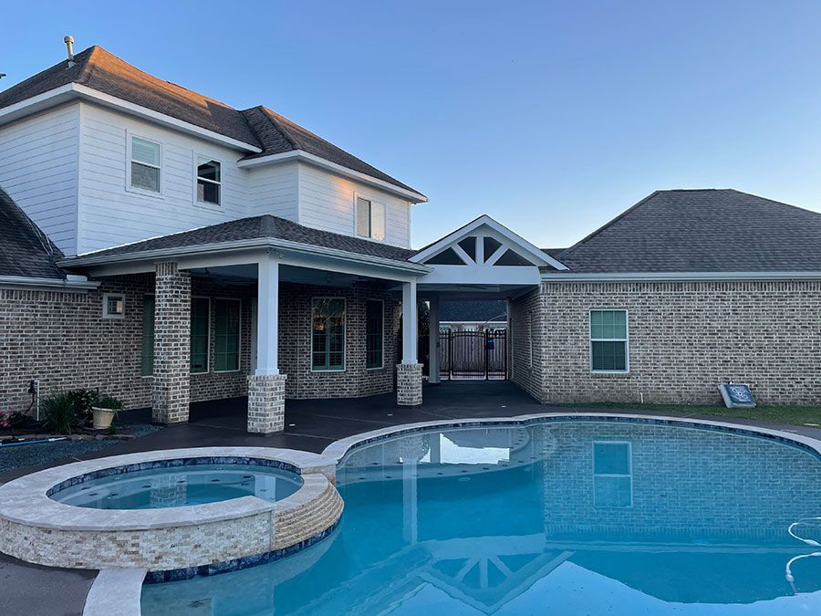 A large house with a large swimming pool in front of it.