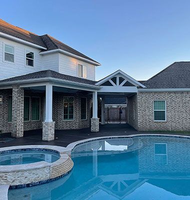 A large house with a large swimming pool in front of it.