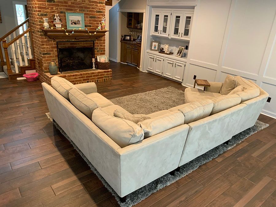 A living room with a large sectional couch and a fireplace.