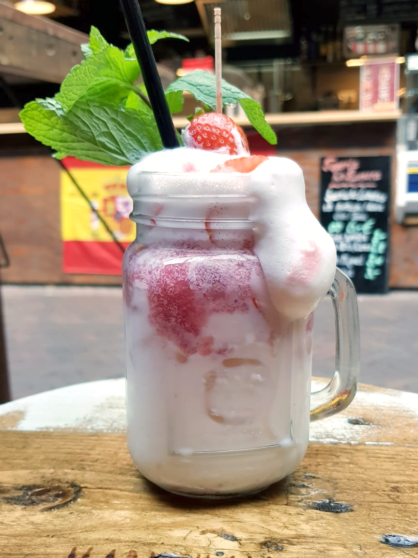 Erdbeercocktail bei dem der Schaum anspruchsvoll herunterläuft. Sehr anschaulich