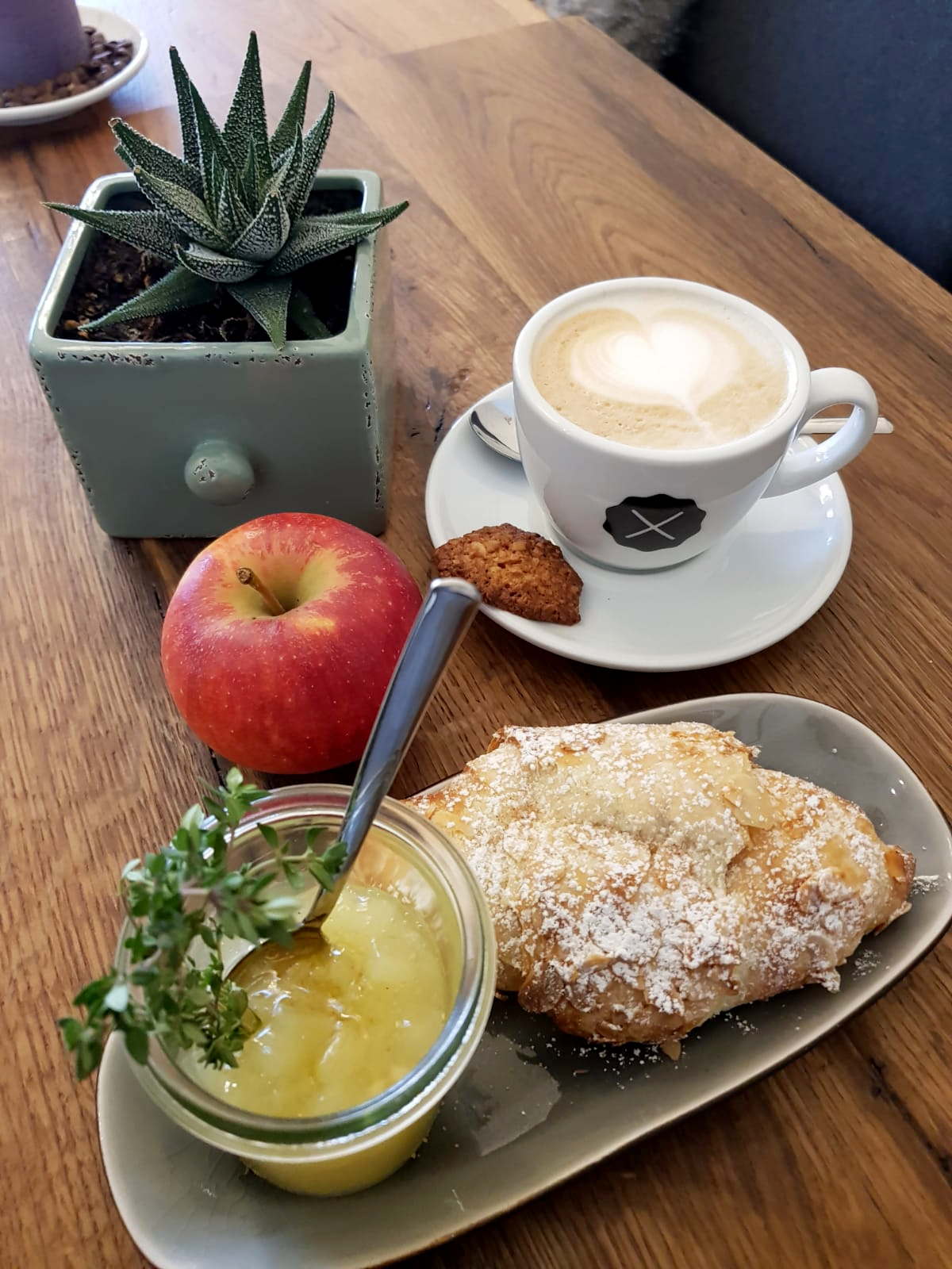 Heißgetränk und dazu einen Apfel auf hübsch dekorierten Tisch