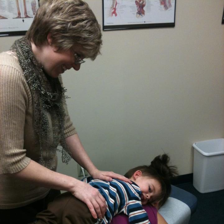 A woman is putting a child 's back on a table